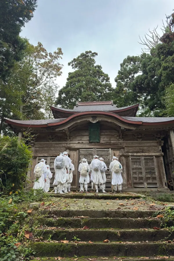 Yamabushi training group praying in front of a shrine in the mountains