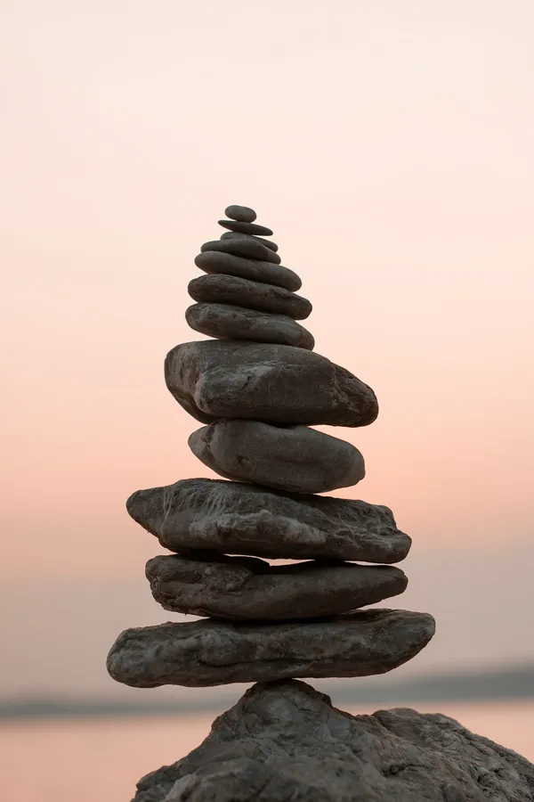 Closeup photography of cairn stones balanced on each other, representing the balance between knowledge and direct experience